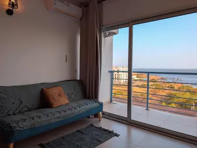 a living room with a couch and a large window at SeafrontView - Cozy T1 Apartment 1 in Praia