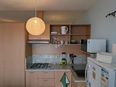 a kitchen with a stove top oven next to a refrigerator at SeafrontView - Cozy T1 Apartment 1 in Praia