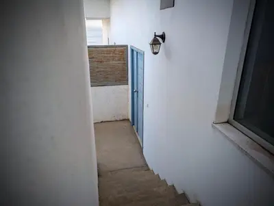 an empty hallway with a blue door and a window at SeafrontView - Cozy T1 Apartment 1 in Praia