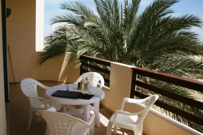 a balcony with a table and chairs and a palm tree at Endless Summer B6 in Sal Rei
