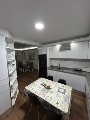 a kitchen with a table and a kitchen with a table and chairs at Apartamento de Luxo -T2 in Praia