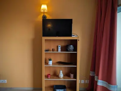 a tv sitting on top of a book shelf at SeafrontView - Cozy T1 Apartment 2 in Praia