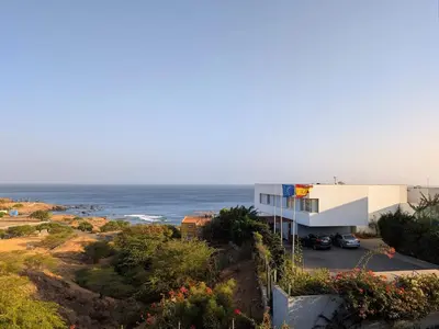 a building on a hill next to the ocean at SeafrontView - Cozy T1 Apartment 3 in Praia