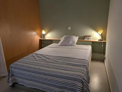 a bed in a small room with two lamps at SeafrontView - Cozy T1 Apartment 3 in Praia