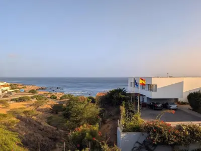 a building on a hill with the ocean in the background at SeafrontView - Cozy T1 Apartment 3 in Praia