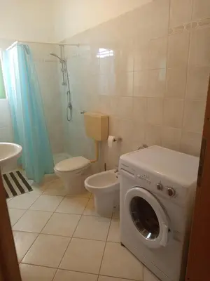 a bathroom with a washing machine and a toilet at Appartamento Teresa in Santa Maria