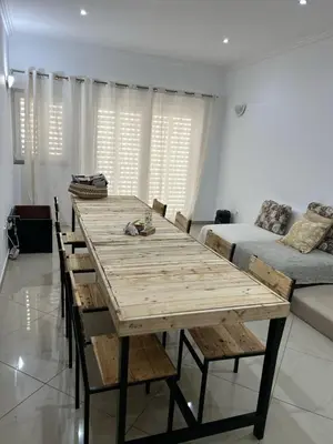 a large wooden table in a living room with a couch at Kubiku Guest House in Praia
