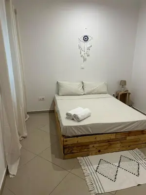 a bedroom with a bed with two towels on it at Kubiku Guest House in Praia