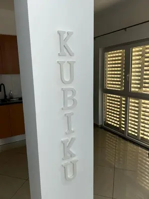 a white wall with a kiss sign in a kitchen at Kubiku Guest House in Praia