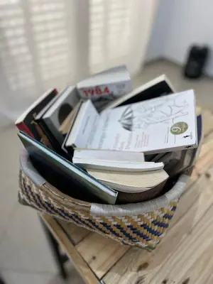 a basket full of books on a table at Kubiku Guest House in Praia