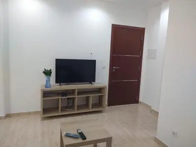 a living room with a flat screen tv and a door at Ladeira apartamentos in Ribeira Grande