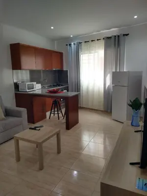 a kitchen and living room with a couch and a table at Ladeira apartamentos in Ribeira Grande