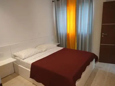 a small bedroom with a bed and a curtain at Ladeira apartamentos in Ribeira Grande
