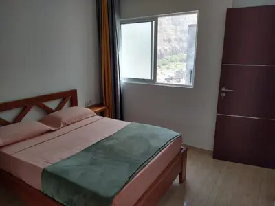 a bedroom with a large bed and a window at Ladeira apartamentos in Ribeira Grande