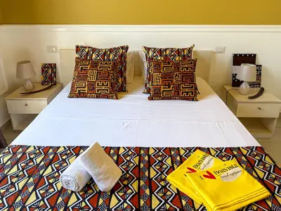 a bedroom with a large white bed with colorful pillows at I LOVE BOA VISTA - Seafront Apartments in Sal Rei