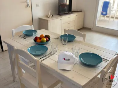 a wooden table with blue plates and a bowl of fruit at I LOVE BOA VISTA - Seafront Apartments in Sal Rei