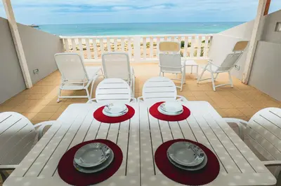 a white table and chairs on a balcony with the ocean at I LOVE BOA VISTA - Seafront Apartments in Sal Rei
