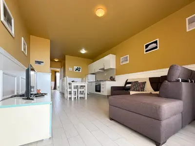 a living room with a couch and a kitchen at I LOVE BOA VISTA - Seafront Apartments in Sal Rei