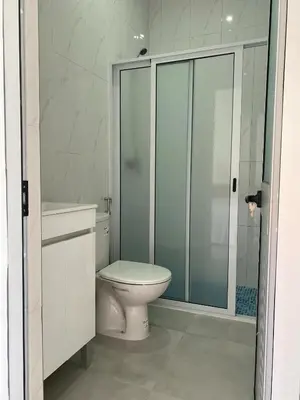 a bathroom with a toilet and a glass shower at Laranjinha Rooms in Paul