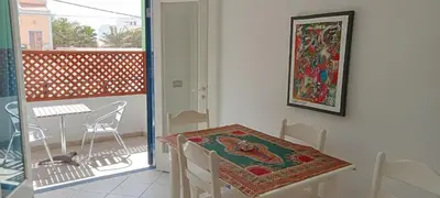 a table and chair in a room with a balcony at Canova Apartment in Santa Maria