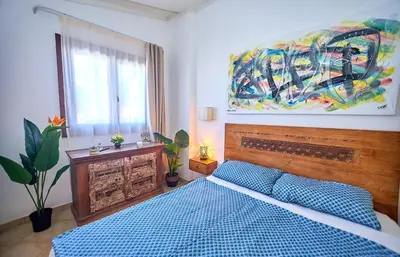 a bedroom with a blue bed and a painting on the wall at Tropical Miradouro in Santa Maria