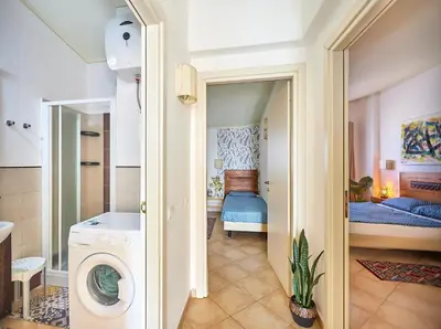 a bathroom with a washing machine and a bedroom at Tropical Miradouro in Santa Maria
