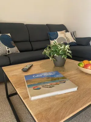 a book on a coffee table in front of a couch at Tropical Miradouro in Santa Maria