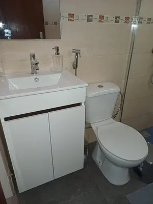 a bathroom with a white toilet and a sink at L&E Apartment in Mindelo