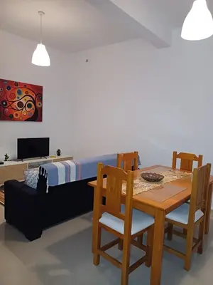 a dining room with a table and chairs and a bed at L&E Apartment in Mindelo