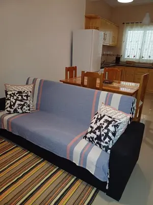 a couch sitting in a living room next to a kitchen at L&E Apartment in Mindelo