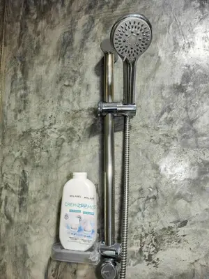 a shower with a blow dryer and a bottle of soap at LAR DO VIAJANTE, Ribeira Grande Santo Antão in Ribeira Grande