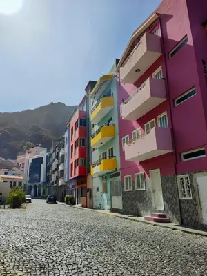 a row of colorful buildings on a cobblestone street at LAR DO VIAJANTE, Ribeira Grande Santo Antão in Ribeira Grande
