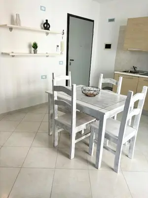 a white dining room table and chairs in a kitchen at Blue Oceano in Santa Maria