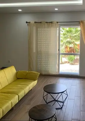 a living room with a yellow couch and a table at Cantinho PeLe in Mindelo