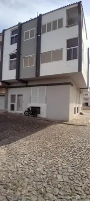 a white building with a motorcycle parked in front of it at Cantinho PeLe in Mindelo