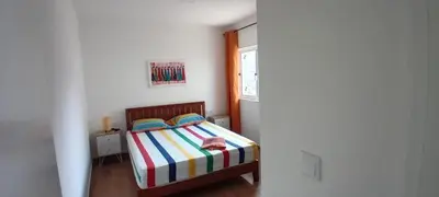 a small bedroom with a bed with a striped blanket at Cantinho PeLe in Mindelo