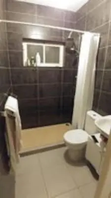 a bathroom with a shower and a toilet and a sink at Casa da Lalá - casa com 3 quartos e espaços exteriores! in Mindelo