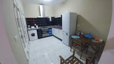 a small kitchen with a table and a refrigerator at Casa da Lalá - casa com 3 quartos e espaços exteriores! in Mindelo