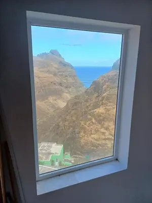 a window in a room with a view of the ocean at Domus Belota in Ribeira Grande