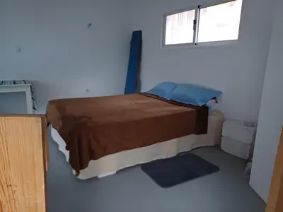 a bedroom with a bed in a room with a window at Domus Belota in Ribeira Grande