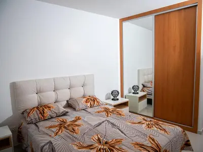 a bedroom with a large bed with a large mirror at Appartement moderne avec vue sur la mer in Praia