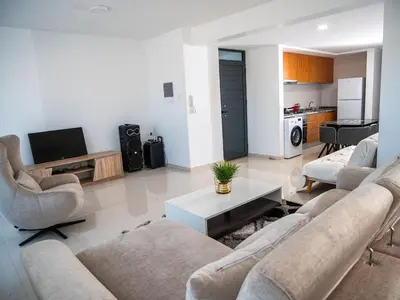 a living room with two couches and a tv at Appartement moderne avec vue sur la mer in Praia
