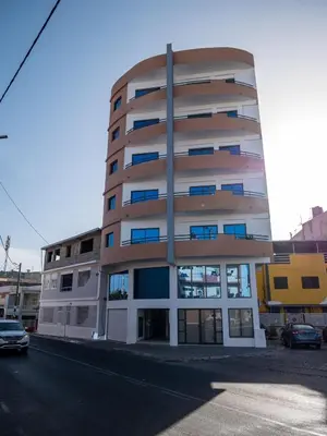a tall apartment building with a round at Appartement moderne avec vue sur la mer in Praia