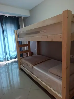 a wooden bunk bed in a room with a window at Elly Apartamentos in Mindelo