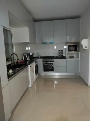 a large kitchen with white cabinets and appliances at Residencia Moreno in Praia