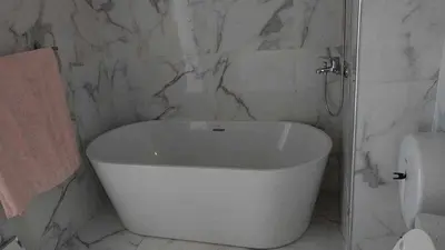 a white bath tub in a bathroom with a toilet at Residencia Moreno in Praia