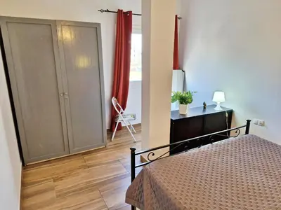 a bedroom with a bed and a dresser with a red curtain at Holiferias NoStress Sal Island in Santa Maria