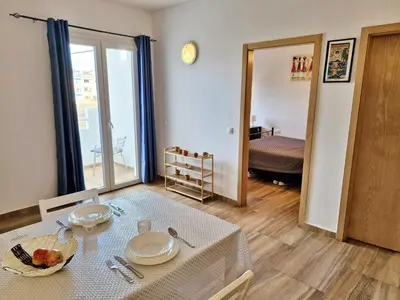 a living room with a table and a room with a bed at Holiferias NoStress Sal Island in Santa Maria