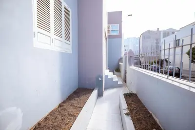 a corridor of a white building with a window at Maya Mindelo 4 in Mindelo