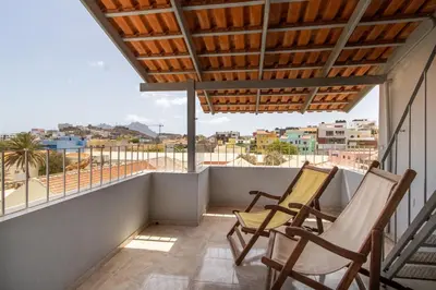 two chairs on a balcony with a view of the city at Maya Mindelo 4 in Mindelo